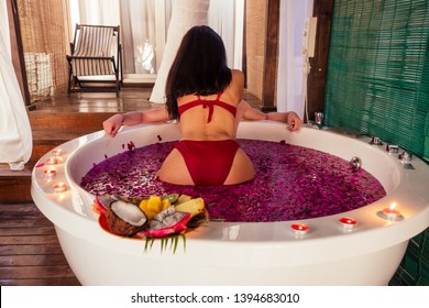 man and woman kissing and hugging romantic fruits, candles and champagne.sex in the water