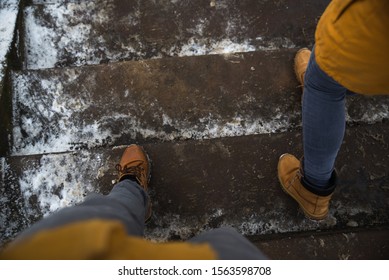 Man And Woman Legs Waking By Icy Slippery Stairs