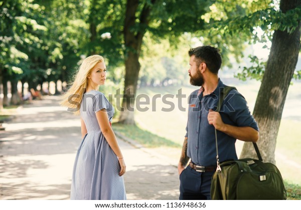 Man and woman likes each other. Man with beard\
and blonde girl stopped to get acquainted. Casual encounter, meet\
on sunny summer day, nature background, defocused. Love at first\
sight concept.