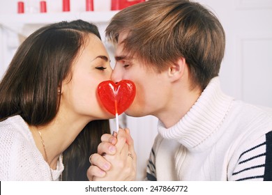 Man and woman with a lollipop in the shape of heart
