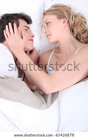 Similar – Image, Stock Photo Young couple in love embracing lying over a bed