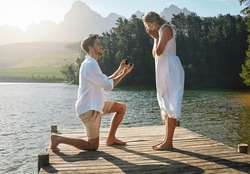 Man, Woman And Marriage Proposal By Lake On Vacation With Surprise, Wow Or Happiness In Sunshine. Couple, Engagement And Offer Ring In Nature For Romance, Love And Happy On Holiday In Summer By Water