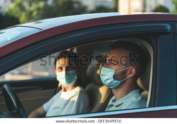 The man and\
woman in masks sitting in the\
car