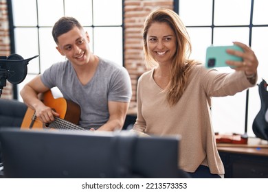 Man And Woman Musicians Having Classic Guitar Lesson Make Selfie By The Smartphone At Music Studio