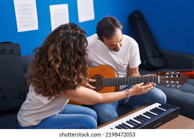 Man And Woman Musicians Having Classical Guitar Lesson At Music Studio