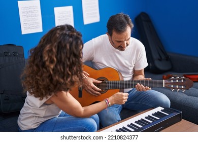 Man And Woman Musicians Having Classical Guitar Lesson At Music Studio