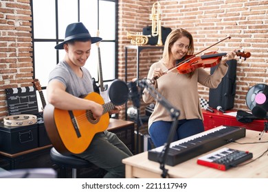 Man And Woman Musicians Playing Violin And Classical Guitar At Music Studio