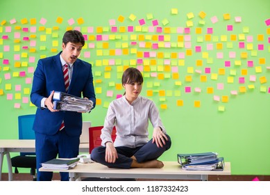 Man And Woman In The Office With Many Conflicting Priorities In 