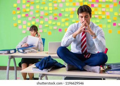 Man And Woman In The Office With Many Conflicting Priorities 