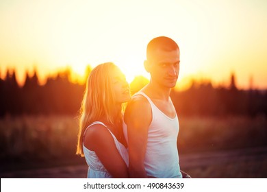 Man with woman on the field on sunset