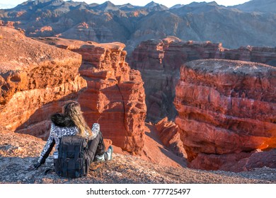 Man Woman On The Top Of The Mountain Looks At The View Of Charyn Canyon Relaxing Rejoices, Concept Of Overcoming Hardship Hiking, Lifestyle Go To Goal