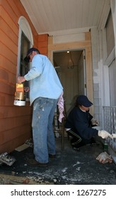 Man And Woman Painting Exterior  Of House