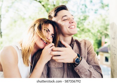 man and woman in a park posing on camera - Shutterstock ID 587336792