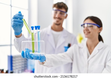 Man And Woman Partners Wearing Scientist Uniform Holding Test Tube At Laboratory