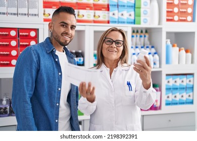 Man And Woman Pharmacist Reading Pills Label Bottle And Prescription At Pharmacy