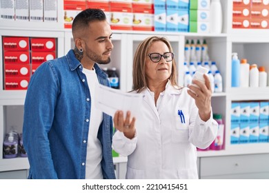 Man And Woman Pharmacist Reading Pills Label Bottle And Prescription At Pharmacy