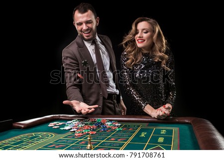 Man with woman playing roulette at the casino. Addiction to the 
