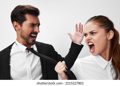 Man And Woman Pulling On Tie Anger Business Looking At Each Other Screaming With Hands Up In White Isolated Background. The Concept Of Business In A Couple Harassment Startup Copy Space