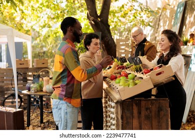 Man and woman receiving fruits samples at farmers market, checking homegrown fruits and veggies at local farmers market. Couple tasting natural fresh products, healthy farm stand. - Powered by Shutterstock