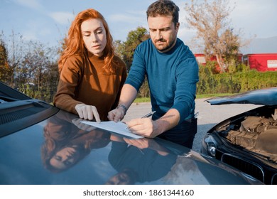 Man And Woman Reporting Damage After Car Accident