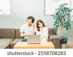 Man and woman in a room (laptop, troubled)