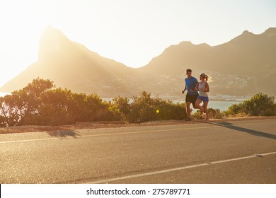 Man and woman running together on an empty road - Powered by Shutterstock