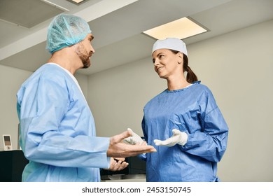 A man and a woman in scrubs having a discussion in a medical setting. - Powered by Shutterstock