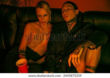 A man and woman are seated on a couch in a room