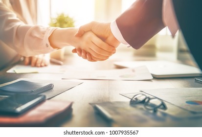 Man and woman are shaking hands in office. Collaborative teamwork.