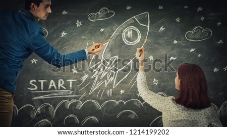 Man and woman sharing thoughts together drawing rocket start on blackboard. Idea exchange, business launch and development. Partnership and teamwork innovation concept as ship take off in cosmos.