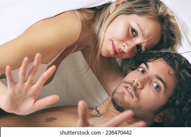 Man And Woman With Shocked Expression Under The Sheet. Fear And Adultery Concept