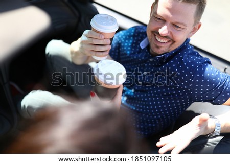 Man and woman sit in car and drink coffee. Friendly communication and dating concept