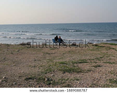 A man and a woman sit together by the Mediterranean Sea during quarantine due to the pandemic (COVID-19) in January 2021 in Haifa, Israel.