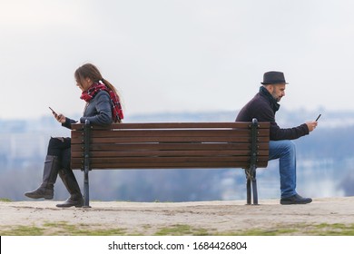 Man And Woman Sitting Apart On A Park Bench