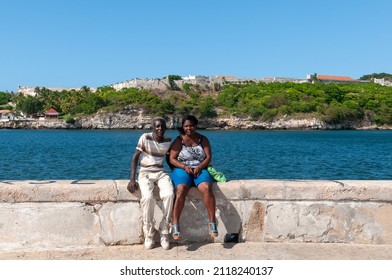 Man and woman sitting by the sea on the avenue of the port in old havana. May 11, 2015. Havana. Cuba.