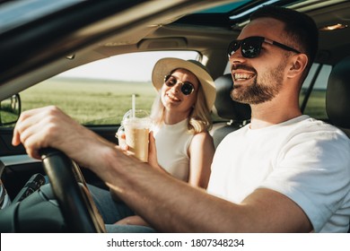 Man And Woman Sitting Inside Car, Drinking Cold Coffee And Enjoying Adventure Road Trip