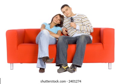 Man And Woman Sitting On A Red Couch With Remote Control.  Isolated On White Background, In Studio.