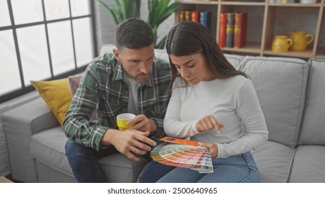 A man and woman sitting on a sofa indoors discussing color swatches together, suggesting home decoration or renovation. - Powered by Shutterstock