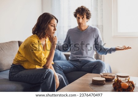 Man and woman are sitting at sofa and arguing. Relationship problems.