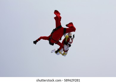 Man and woman are skydiving in the cloudy sky.