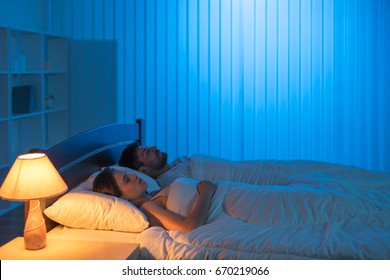 The Man And Woman Sleeping In The Bedroom. Night Time