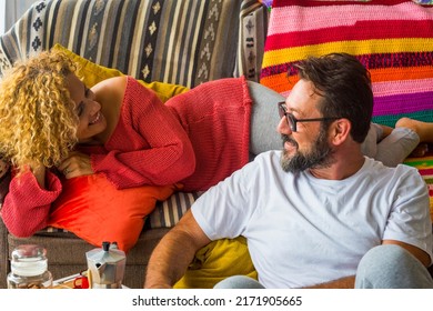 Man And Woman Smile And Enjoy Leisure Activity At Home In Morning Breakfast Time Together. People Sitting On The Sofa In Apartment For Real Life. Couple Smiling And Looking Each Other With Love