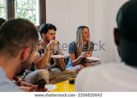 man and woman smile as they listen to a friend speak