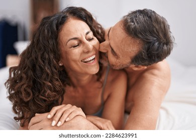 Man and woman smiling confident lying on bed kissing at bedroom - Powered by Shutterstock