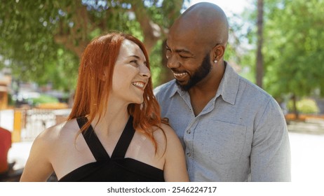 Man and woman smiling at each other in an outdoor urban park, showcasing their interracial relationship and expressing love and happiness together. - Powered by Shutterstock