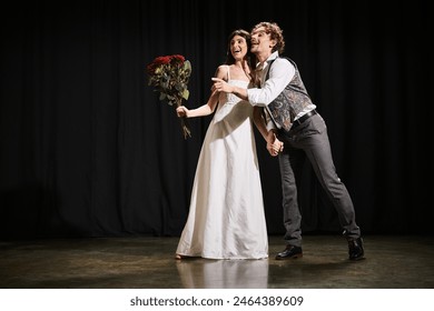 A man and a woman stand confidently on a theater stage during rehearsals. - Powered by Shutterstock