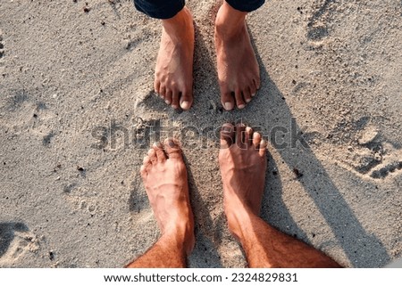 Man and woman standing bare feet on sand at beach on the holiday