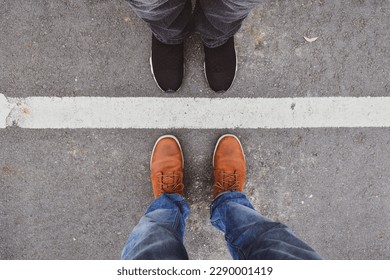 Man and woman standing close on either side of white line. Couple relationship concept.