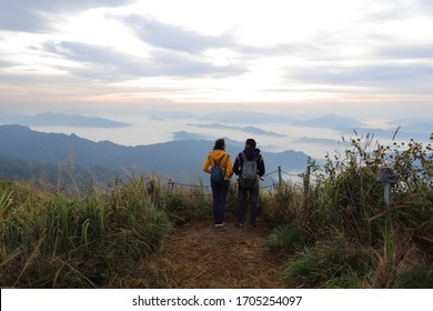 Man and woman standing in the fog and mountain view at Phu Chi Fa National Park, Chiang Rai, Thailand