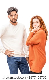 A man and a woman are standing next to each other. The man is wearing a white shirt and blue jeans, while the woman is wearing an orange sweater. They both have a serious expression on their faces
